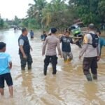 Anggota Polsek Batang Cenaku beserta warga sekitar membantu menyeberangkan kendaraan yang melintas.