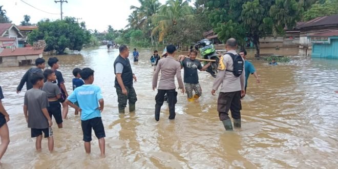 Anggota Polsek Batang Cenaku beserta warga sekitar membantu menyeberangkan kendaraan yang melintas.